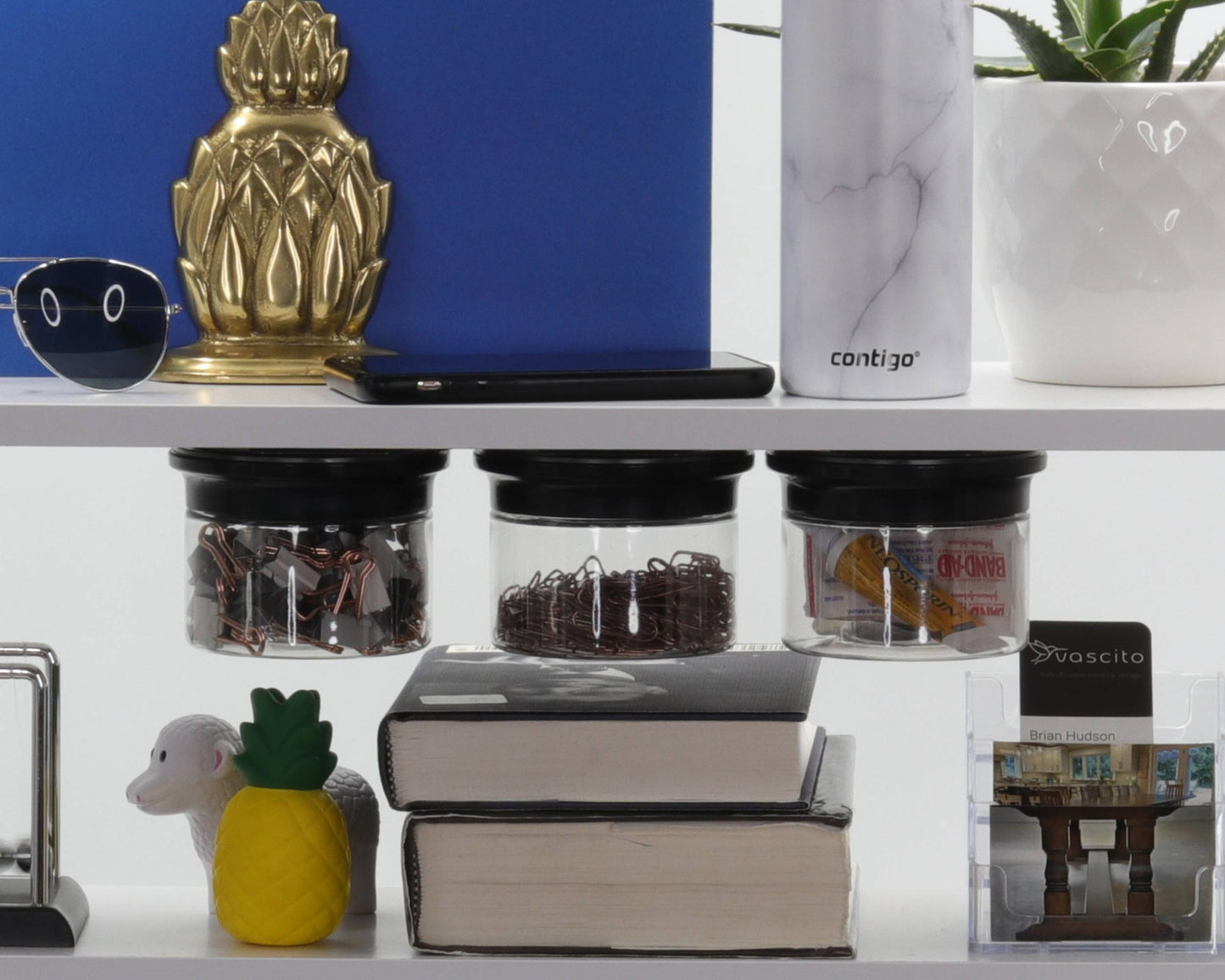 Stash Jars - Magnetic Storage Solution mounted under shelf for organizing office supplies like paper clips and binder clips in a modern workspace.