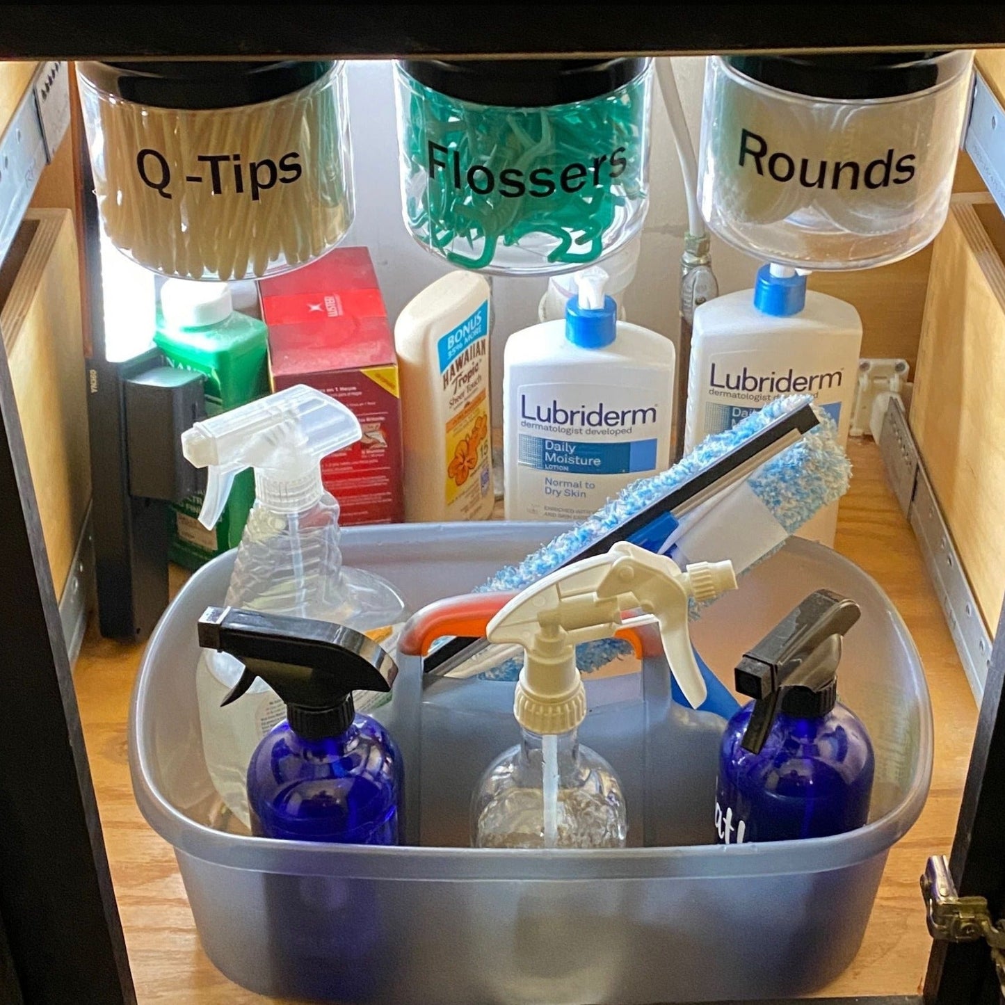 Under Sink/Under Shelf Organizer, Stainless POS jars mounted under sink storing hygiene items, maximizing vertical cabinet space in bathroom.