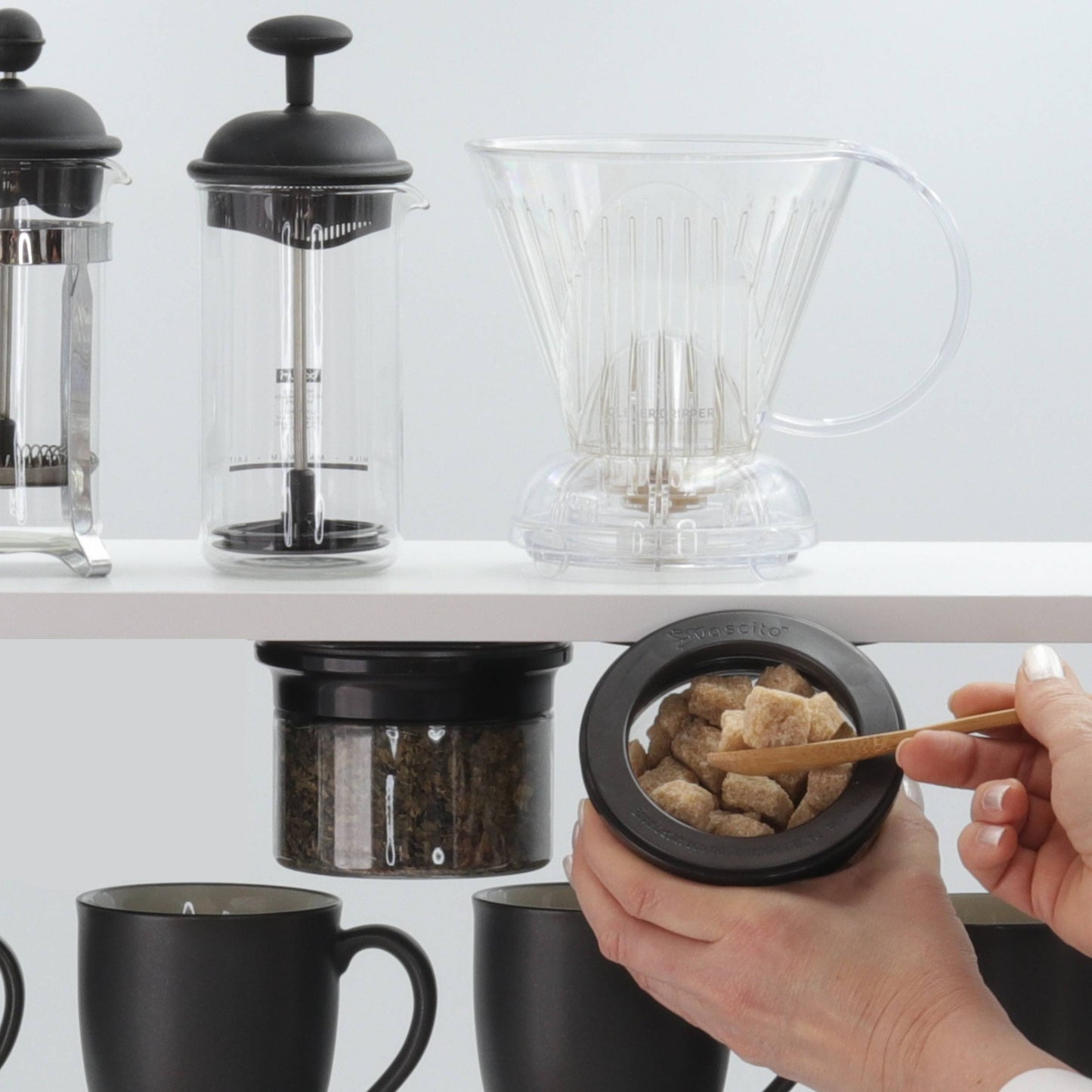 Kitchen Organizer Stash Jar storing sugar cubes under shelf near coffee accessories, perfect for tea and coffee stations.