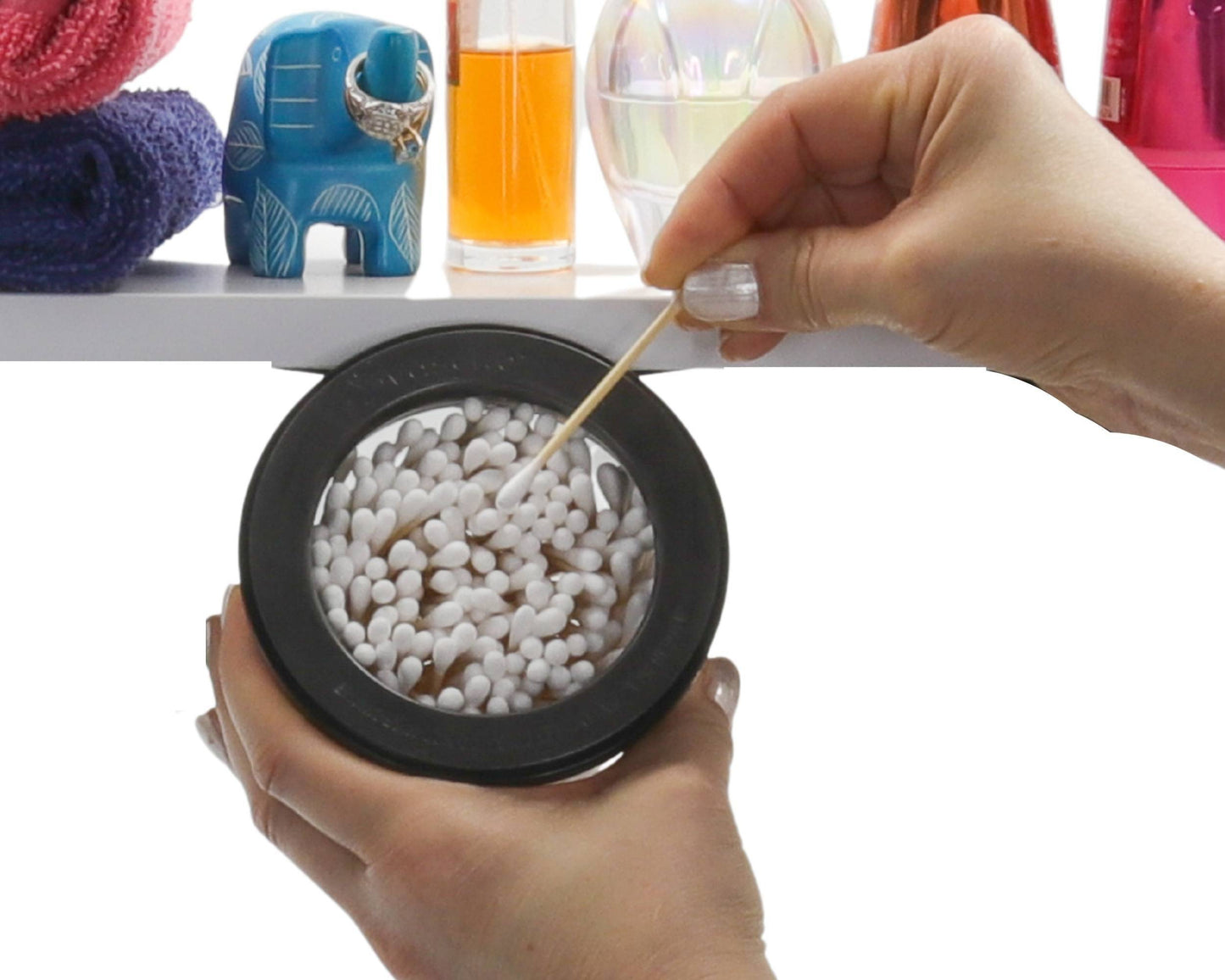 Close-up of hand removing Q tip from black-lidded Cotton Ball Holder & Q Tip Organizer, perfect for compact bathroom storage.