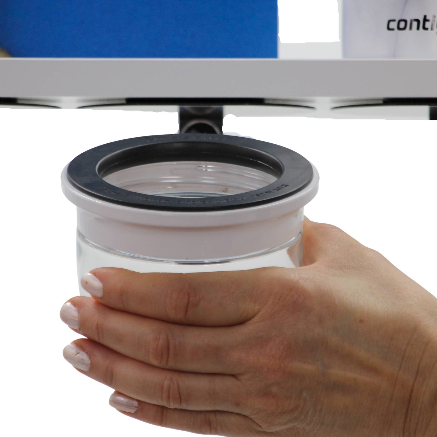 Hand holding a clear Office Stash Jar - Magnetic Jar with white lid, illustrating easy grip and ergonomic design for quick access.