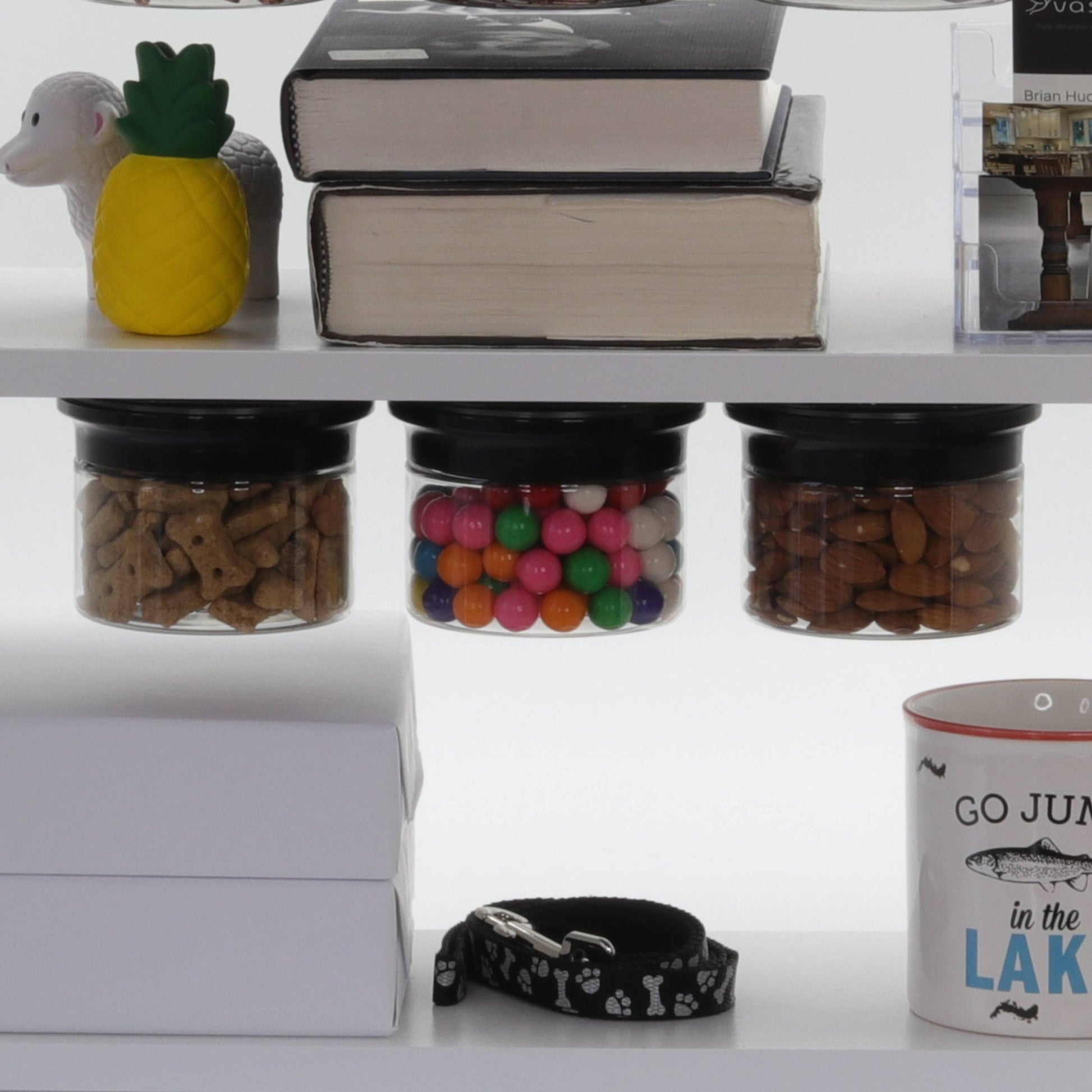 Three stash jars mounted under a shelf storing dog treats, gumballs, and almonds, ideal for kitchen or pantry organization.