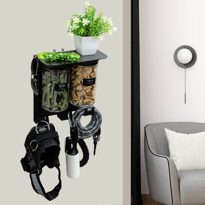 Dog leash holder mounted on wall with pet treats and gear, modern black design with flowers on top shelf for decorative touch.