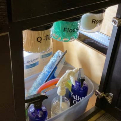 Under Sink/Under Shelf Organizer, Stainless POS system with labeled jars for flossers and Q-tips under bathroom cabinet for organized storage.
