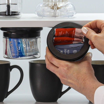 Hand accessing tea packets from under-shelf Kitchen Organizer Stash Jar, perfect for small kitchens and RVs.