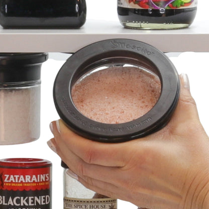 Hand holding airtight Kitchen Organizer Stash Jar filled with pink Himalayan salt, ideal for spice and seasoning storage.